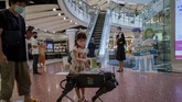 Aktivitas New Normal di Thailand A child disinfects her hands from a mobile robot that carries a container of sanitization liquid at Central World, an upmarket shopping mall in Bangkok, Thailand, Wednesday, May 27, 2020. Thai government continues to ease restrictions related to running business in capital Bangkok that were imposed weeks ago to combat the spread of COVID-19. (AP Photo/Gemunu Amarasinghe)