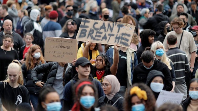 Demonstrators hold placards during a march in central Auckland, New Zealand, Monday, June 1, 2020, to protest the death of United States' George Floyd, a black man who died in police custody in Minneapolis on May 25. Floyd, who after a white police officer who is now charged with murder, Derek Chauvin, pressed his knee into Floyd's neck for several minutes even after he stopped moving and pleading for air. (Dean Purcell/New Zealand Herald via AP)