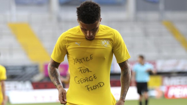 Jadon Sancho of Borussia Dortmund celebrates scoring his teams second goal of the game with a 'Justice for George Floyd' shirt during the German Bundesliga soccer match between SC Paderborn 07 and Borussia Dortmund at Benteler Arena in Paderborn, Germany, Sunday, May 31, 2020. Because of the coronavirus outbreak all soccer matches of the German Bundesliga take place without spectators. (Lars Baron/Pool via AP)