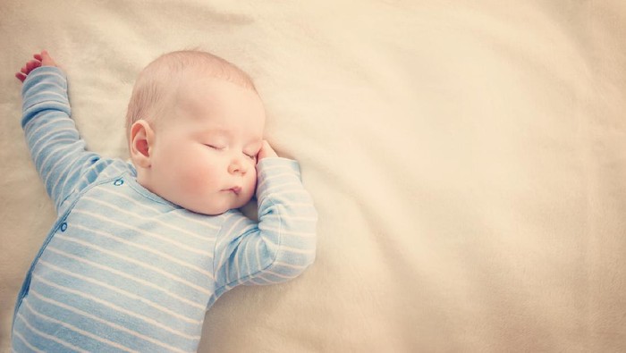 little boy sleeping on soft white blanket