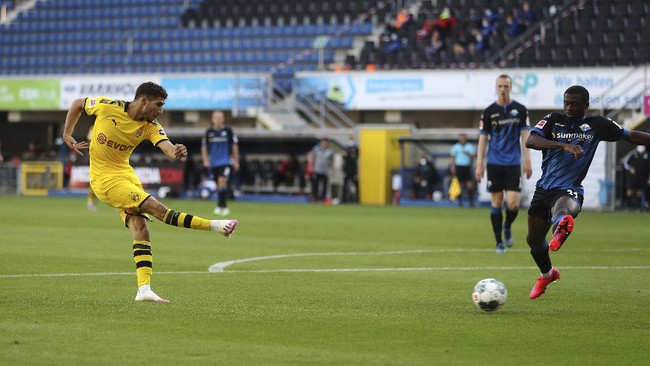 Achraf Hakimi Mouh of Borussia Dortmund scores his teams fourth goal during the German Bundesliga soccer match between SC Paderborn 07 and Borussia Dortmund at Benteler Arena in Paderborn, Germany, Sunday, May 31, 2020. Because of the coronavirus outbreak all soccer matches of the German Bundesliga take place without spectators. (Lars Baron/Pool via AP)