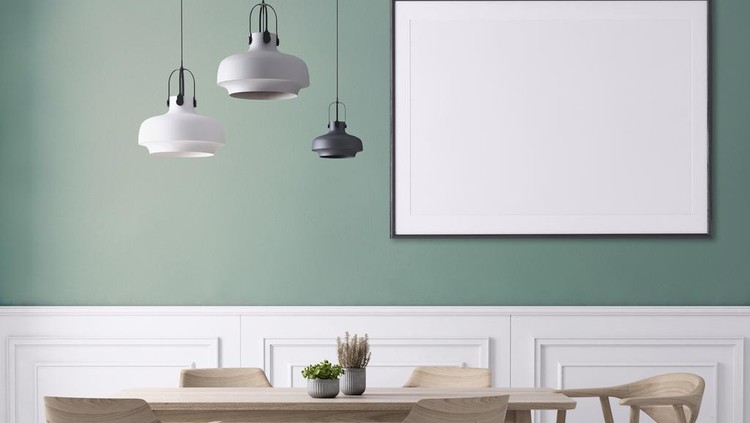 Dining room interior apartment with wooden chairs and table with plant. Pendant lamp, white polished floor and pastel colored wall with picture frame template for copy space.