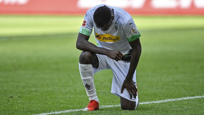 Moenchengladbach's Marcus Thuram taking the knee after scoring his side's second goal during the German Bundesliga soccer match between Borussia Moenchengladbach and Union Berlin in Moenchengladbach, Germany, Sunday, May 31, 2020. The German Bundesliga becomes the world's first major soccer league to resume after a two-month suspension because of the coronavirus pandemic. (AP Photo/Martin Meissner, Pool)