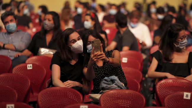 Spectators take a selfie while waiting for the start of a concert by Portuguese artists Bruno Nogueira and Manuela Azevedo at the Campo Pequeno bullring in Lisbon, Monday, June 1, 2020. Portugal is allowing concert halls to reopen from Monday as the government eases the coronavirus lockdown rules. (AP Photo/Armando Franca)