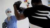Mantan Petarung Tinju Beri Pelatihan ke Petugas Medis In this Wednesday, May 27, 2020 photo, medical worker Kenza, left, boxes during a training session with French boxer Hassan N’Dam at the Villeneuve-Saint-Georges hospital, outside Paris. A world champion French boxer is taking his skills to hospitals, coaching staff to thank the medical profession for saving his father-in-law from the virus, and giving them new confidence and relief from their stressful jobs. (AP Photo/Christophe Ena)