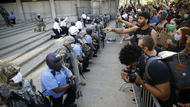Philadelphia police and National Guard take a knee at the suggestion of Philadelphia Police Deputy Commissioner Melvin Singleton, unseen, outside Philadelphia Police headquarters in Philadelphia, Monday, June 1, 2020 during a march calling for justice over the death of George Floyd, Floyd died after being restrained by Minneapolis police officers on May 25. (AP Photo/Matt Rourke)