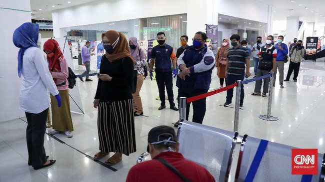 Petugas mengatur warga yang akan melakukan perpanjangan SIM di Mal Pelayanan Publik Bekasi Trade Center, Bekasi, Jawa Barat, Selasa, 2 Juni 2020.  Pelayanan perpanjangan SIM ini tetap menerapkan protokol pencegahan covid-19. CNNIndonesia/Safir Makki