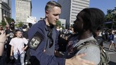 Cinta dan Respek di Tengah Aksi Antirasisme George Floyd Louisville Metro Police Department officer William Vogt, front left, talks with a protester Monday, June 1, 2020, in Louisville, Ky. The protest was over the deaths of George Floyd and Breonna Taylor. Taylor, a black woman, was fatally shot by police in her home in March and Floyd, a black man, died after being restrained by Minneapolis police officers on May 25. (AP Photo/Darron Cummings)
