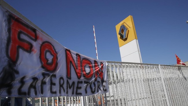 A union banner reading "No to the closure" hangs on the fence of the Renault plant Friday, May 29, 2020 in Choisy-le-Roi, outside Paris. Struggling French carmaker Renault announced 15,000 job cuts worldwide as part of a 2 billion euros cost-cutting plan over three years. The cost-cutting plan comes as Renault came into the virus crisis in particularly bad shape. Its alliance with Nissan and Mitsubishi is a major global auto player but has struggled since the 2018 arrest of its longtime star CEO Carlos Ghosn. (AP Photo/Christophe Ena)