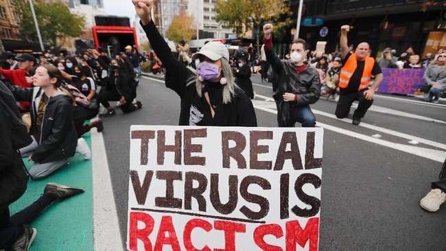 Demonstrators gesture during a march in central Auckland, New Zealand, Monday, June 1, 2020, to protest the death of United States' George Floyd, a black man who died in police custody in Minneapolis on May 25. Floyd, who after a white police officer who is now charged with murder, Derek Chauvin, pressed his knee into Floyd's neck for several minutes even after he stopped moving and pleading for air. (Dean Purcell/New Zealand Herald via AP)