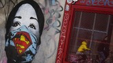 seni Jalanan Dalam tawa dan harapan A mother and her child are reflected as they pass a mural by artist FAKE, titled