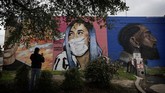 Seni Jalanan Dalam tawa dan harapan A woman photographs a mural of Cardi B that was updated by the artist Colton Valentine to include a face mask during the coronavirus outbreak in San Antonio, Monday, March 30, 2020. (AP Photo/Eric Gay)