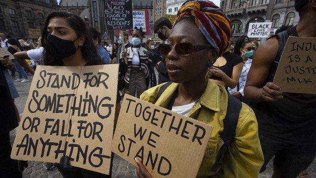 People take part in a Black Lives Matter protest in Amsterdam, Netherlands, Monday, June 1, 2020, to protest against the recent killing of George Floyd, a black man who died in police custody in Minneapolis, U.S.A., after being restrained by police officers on Memorial Day. (AP Photo/Peter Dejong)