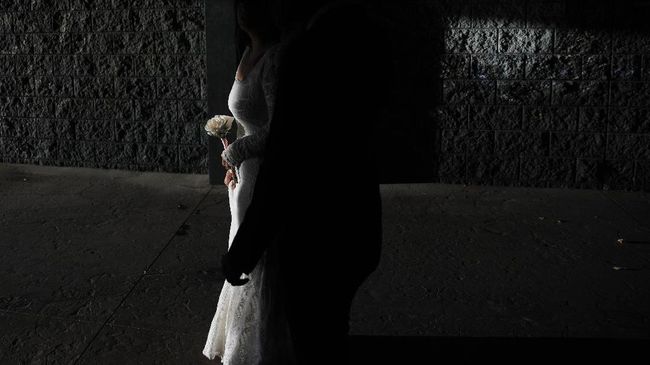 Haillie Bernal holds flowers while walking with Angel Martinez after getting married at Vegas Weddings, Friday, May 8, 2020, in Las Vegas. (AP Photo/John Locher)