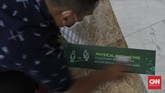 Kesiapan Mall Jelang New Normal Petugas memasang stiker tanda jaga jarak di Mal Central Park, Jakarta, Rabu (3/6/2020). CNN Indonesia/Adhi Wicaksono