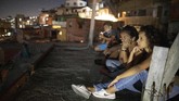Layar Tancep, Pelipur Lara Kala Pandemi di Caracas Residents sit on their roof to watch the film Aladdin projected on a screen set up on the roof of a neighbor's home in the Petare neighborhood of Caracas, Venezuela, late Monday, June 1, 2020. A neighborhood group called The Download Zone set up the movie as a free entertainment option for families cooped up since mid-March under the COVID-19 quarantine. (AP Photo/Ariana Cubillos)