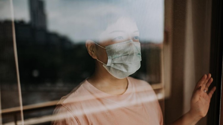 an asian chinese female looking out from her balcony window with her face mask during the restricted movement order in malaysia