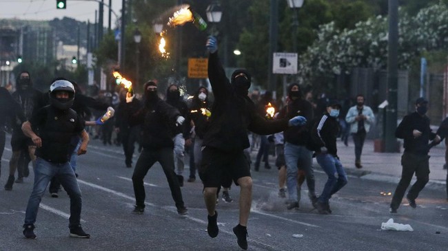 Masked protesters hurl petrol bombs towards the direction of riot police officers during minor scuffles outside the U.S. embassy in Athens, Wednesday, June 3, 2020, following a demonstration over the death of George Floyd, a black man who died after being restrained by Minneapolis police officers on May 25. Greek police have fired tear gas to disperse youths who attacked them following an otherwise peaceful demonstration by about 4,000 people. (AP Photo/Lefteris Pitarakis)