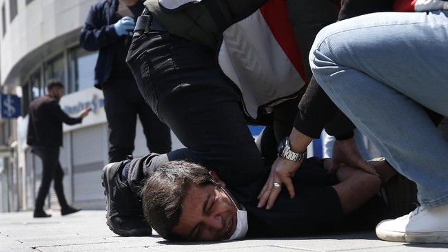 FILE - In this May 1, 2020, file photo, Turkish police officers arrest a demonstrator wearing a face mask for protection against the coronavirus, during May Day protests near Taksim Square, in Istanbul. The death of George Floyd has renewed scrutiny of immobilization techniques long used in policing around the world. (AP Photo/Emrah Gurel, File)