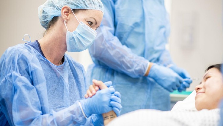 Team of doctors and nurses wear masks and gloves and prepare for surgery.