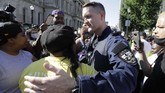 Momen Haru di Tengah Aksi Protes Kematian George Floyd di AS Louisville Metro Police Department officer William Vogt hugs a protester, Monday, June 1, 2020, in Louisville, Ky. The protest was over the deaths of George Floyd and Breonna Taylor. Taylor, a black woman, was fatally shot by police in her home in March and Floyd, a black man, died after being restrained by Minneapolis police officers on May 25. (AP Photo/Darron Cummings)
