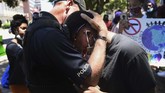Momen Haru di Tengah Aksi Protes Kematian George Floyd di AS A police officer and a demonstrator hug as people gather in Shreveport, La., Sunday, May 31, 2020. They marched to the Caddo Parish Courthouse for Black Lives Matter. (Henrietta Wildsmith/The Shreveport Times via AP)