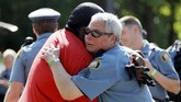 Momen Haru di Tengah Aksi Protes Kematian George Floyd di AS Gemini Stone Pollard, left, hugs a police officer Monday, June 1, 2020, in St. Paul, Minn. Protests continued following the death of George Floyd, who died after being restrained by Minneapolis police officers on Memorial Day. (AP Photo/Julio Cortez)