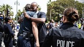 Momen Haru di Tengah Aksi Protes Kematian George Floyd di AS Pastor Calvin Sparks, of Life Pavilion in Carson, hugs LAPD officers after some officers took a knee with clergy and marchers at LAPD Headquarters during a demonstration demanding justice for George Floyd, Tuesday, June 2, 2020 in Los Angeles, Floyd, a black man, died after being restrained by Minneapolis police officers on May 25. (Sarah Reingewirtz/The Orange County Register via AP)