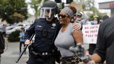 Momen Haru di Tengah Aksi Protes Kematian George Floyd di AS A San Jose Police officer gives a protester a hug during a protest over the death of George Floyd outside of San Jose City Hall in downtown San Jose, Calif., on Sunday, May 31, 2020. (Nhat V. Meyer/Bay Area News Group)