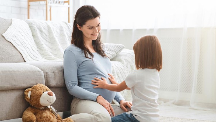 hamil Curious little daughter touching her pregnant mother big tummy, home interior