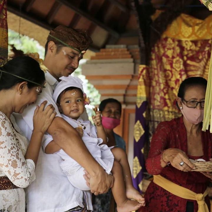 <p>Upacara syukuran 3 Oton untuk Rayidaru, Bunda. Si adik nampak anteng digendong Ayah Tjokorda nih. (Foto: Instagram @happysalma) </p>