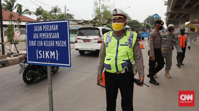 Petugas gabungan memeriksa kelengkapan surat pengendara yang akan masuk wilayah Jakarta terkait penerapan PSBB Transisi, Jakarta, Jumat, 5 Juni 2020. Direktorat Lalu Lintas Polda Metro Jaya tetap melakukan pemeriksaan pelanggaran pembatasan sosial berskala besar (PSBB) di 67 titik di wilayah DKI Jakarta selama masa transisi.CNNIndonesia/Safir Makki