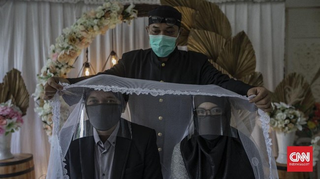Suasana akad nikah di Kantor Urusan Agama (KUA) kecamatan Ciracas, Jakarta, Sabtu, 6 Juni 2020. Sesuai dengan SE Nomor 15 Tahun 2020 Tentang Panduan Penyelenggaraan Kegiatan di Rumah Ibadah Dalam Mewujudkan Masyarakat Produktif dan Aman Covid-19 di Masa Pandemi, calon pengantin diharuskan mengikuti protokol kesehatan seperti menggunakan masker dan sarung tangan. CNN Indonesia/Bisma Septalisma