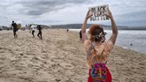 Penghormatan Para Surfer untuk George Floyd Shawna Ventimiglia, holds a sign in support of a local group of surfers during a traditional paddle out ceremony in Hermosa Beach in support of Black Lives Matter over the death of George Floyd in Los Angeles, Friday June 5, 2020. People protest over the death of George Floyd after he died in police custody in Minneapolis on May 25. (AP Photo/Richard Vogel)