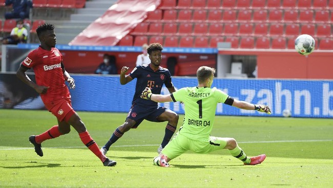 Kingsley Coman of Munich scores his team's first goal past goalkeeper Lukas Hradecky of Leverkusen during the German Bundesliga soccer match between Bayer Leverkusen and Bayern Munich in Leverkusen, Germany, Saturday, June 6, 2020. (Matthias Hangst, Pool via AP)