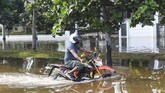BANJIR ROB PANTAI MUTIARA Pengendara motor melintas saat banjir rob menggenangi Kompleks Pantai Mutiara, Penjaringan, Jakarta, Minggu (7/6/2020). Banjir di kawasan tersebut diduga akibat adanya tanggul yang jebol saat naiknya permukaan air laut di pesisir utara Jakarta. ANTARA FOTO/Hafidz Mubarak A/foc.