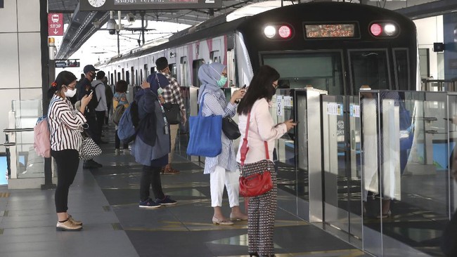 Passengers wearing face masks stand near a MRT train station in Jakarta, Indonesia, Monday, June 8, 2020. Indonesia’s capital of Jakarta, the city hardest hit by the new coronavirus, has partly reopened after two months of partial lockdown as the world’s fourth most populous nation braces to gradually reopen its economy. (AP Photo/Tatan Syuflana)