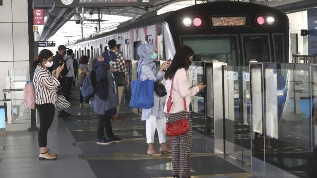 aktivitas warga masa transisi PSBB Passengers wearing face masks stand near a MRT train station in Jakarta, Indonesia, Monday, June 8, 2020. Indonesia’s capital of Jakarta, the city hardest hit by the new coronavirus, has partly reopened after two months of partial lockdown as the world’s fourth most populous nation braces to gradually reopen its economy. (AP Photo/Tatan Syuflana)