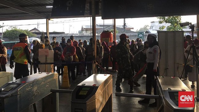 Sejumlah penumpang stasiun Bekasi mengantre untuk masuk ke dalam kereta pda hri pertama pemberlakuan PSBB Transisi, Senin (8/6)