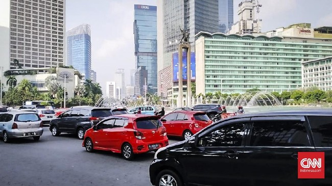 Kendaraan bermotor, mulai dari sepeda motor, mobil, dan angkutan umum melintas di Bundaran HI, Jalan Jenderal Sudirman-MH. Thamrin, saat hari pertama perkantoran dibuka dalam PSBB transisi, Senin (8/6).