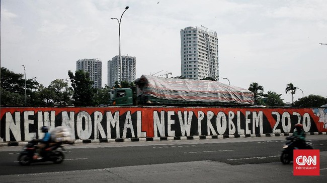 Pengendara melintasi mural bertema 'New Normal New Problem' di kawasan Tanjung Barat, Jakarta, Selasa (9/6/2020). Mural itu pesan menyambut era tatanan kehidupan baru ketika setiap orang harus mengedepankan protokol kesehatan saat berkegiatan di tengah pandemi COVID-19. CNN Indonesia/Andry Novelino