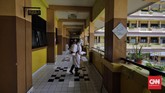 Penyemprotan Disinfektan di Sekolah Anggota Palang Merah Indonesia menyemprotkan desinfektan dalam upaya menahan penyebaran virus corona di dalam ruang kelas di SMPN 139 dan SDN Malaka Jaya 04 Pagi. Jakarta, Selasa, 9 Juni 2020. (CNN Indonesia/ Adhi Wicaksono)