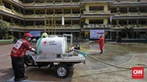 Penyemprotan Disinfektan di Sekolah Anggota Palang Merah Indonesia menyemprotkan desinfektan dalam upaya menahan penyebaran virus corona di dalam ruang kelas di SMPN 139 dan SDN Malaka Jaya 04 Pagi. Jakarta, Selasa, 9 Juni 2020. (CNN Indonesia/ Adhi Wicaksono)