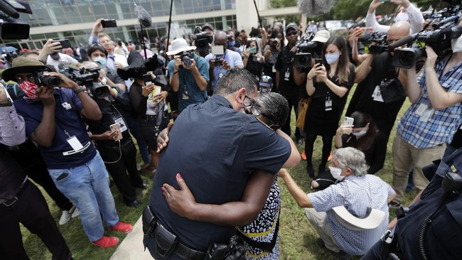 Houston police chief Art Acevedo and Charlene Davis embrace after Davis prayed for him as she stood in line at a public visitation for George Floyd at The Fountain of Praise church in Houston, Monday, June 8, 2020, in Houston.(AP Photo/Eric Gay)