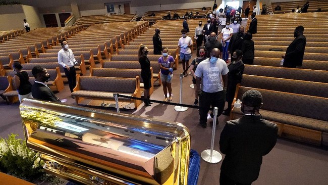 Mourners pass by the casket of George Floyd during a public visitation for Floyd at the Fountain of Praise church Monday, June 8, 2020, in Houston. (AP Photo/David J. Phillip, Pool)