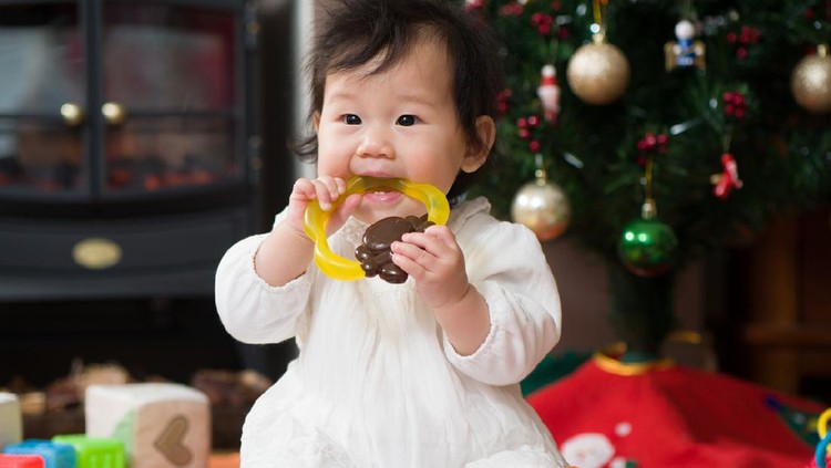 Teething baby girl playing with teething toy