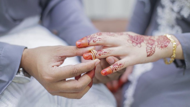 Groom put a wedding ring on bride hand