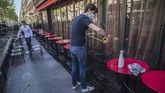 Kafe di Paris Kembali Buka Pierre-Antoine Boureau handles a tape measure as he prepares the terrace of a restaurant in order to respect social distancing to help curb the spread of the coronavirus in Paris, Monday, June 1, 2020. (AP Photo/Michel Euler)
