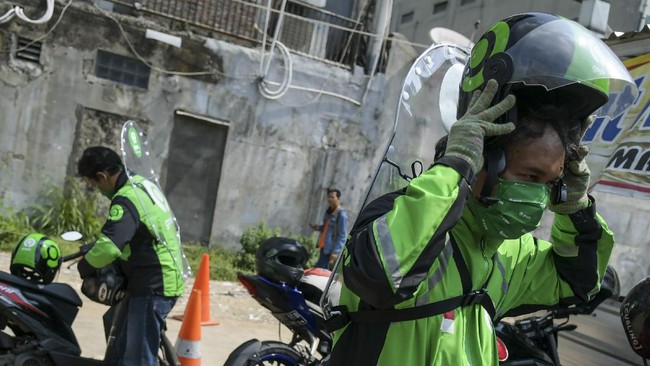 Pengemudi ojek daring mengenakan sekat pelindung saat menunggu penumpang di kawasan jalan Kendal, Jakarta, Rabu (10/6/2020). Penggunaan sekat pelindung untuk pembatasan antara pengemudi dan penumpang tersebut sebagai bentuk penerapan protokol kesehatan guna meminimalisir risiko penyebaran virus COVID-19 dalam menghadapi era normal baru. ANTARA FOTO/Galih Pradipta/aww.