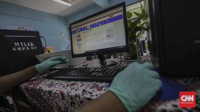 Petugas mempersiapkan fasilitas yang akan digunakan untuk penerimaan peserta didik baru (PPDB) di SMP Negeri 60 Jakarta, Kamis, 11 Juni 2020. Kementerian Pendidikan dan Kebudayaan (Kemendikbud) secara resmi menetapkan tahun ajaran baru 2020-2021 dimulai pada 13 Juli 2020. CNN Indonesia/Bisma Septalisma